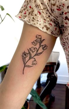 a woman's arm with a flower tattoo on the left side of her body