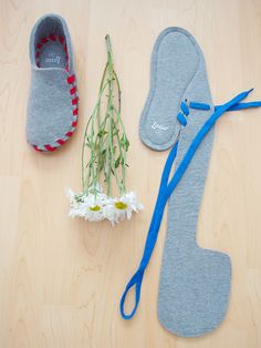 a pair of slippers and flowers are on the floor next to some felt shoes