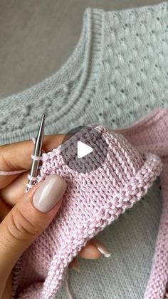 a woman is holding a knitted object in her hand with a crochet hook