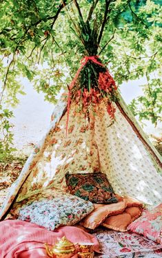 a teepee is set up with pillows and blankets