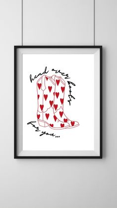 a red and white cowboy boot with hearts on it is mounted in a black frame