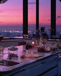 the kitchen counter is covered with dishes and utensils as the sun sets in the distance