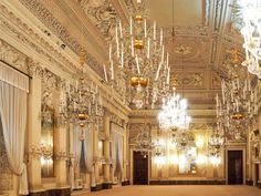 an ornate room with chandeliers and curtains