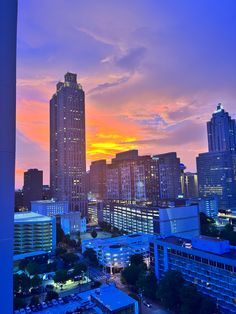 the city skyline is lit up at sunset