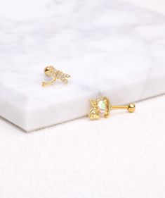 a pair of gold plated earrings on a marble surface