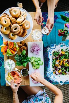 a woman sitting at a table with plates of food on it and bowls of vegetables