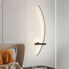 a bed room with a neatly made bed and a wall mounted light