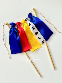 three colorful bags with paw prints on them and two wooden sticks sticking out of the bag