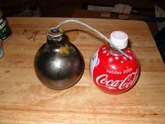 an old coca - cola can and a christmas ornament on a cutting board