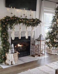 a living room decorated for christmas with stockings and garlands on the fireplace mantel