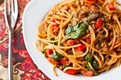 a white plate topped with spaghetti and vegetables