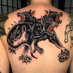 the back of a man's upper half with tattoos on his body and an animal