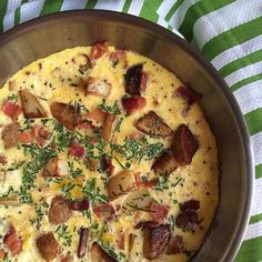 a pizza sitting on top of a metal pan covered in cheese and bacon toppings