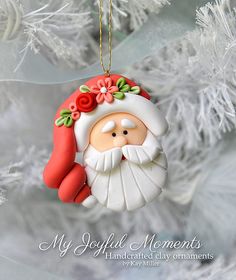 a christmas ornament with a santa clause on it's head hanging from a tree