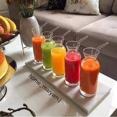 a tray filled with different types of juices on top of a table next to a couch