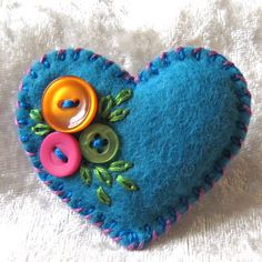 a blue heart with buttons and leaves on it