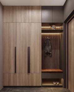 a wooden closet with shoes and coat hanging on it