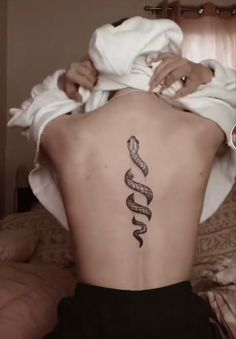 a woman with a snake tattoo on her back