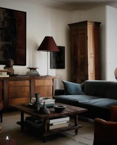 a living room filled with furniture and a painting on the wall above it's coffee table