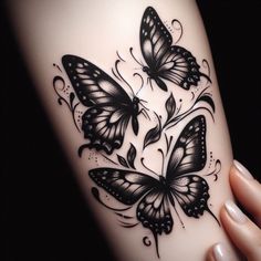 a woman's arm with black and white butterflies on the back of her leg