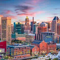 the city skyline is lit up at sunset