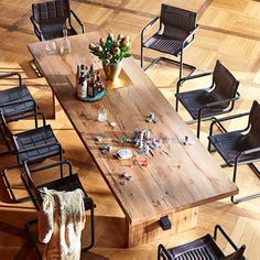 a wooden table surrounded by black chairs and other items on the floor in an empty room