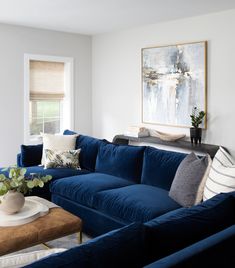 a living room filled with blue couches and pillows