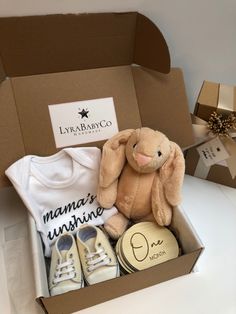 a baby gift box with a teddy bear, t - shirt and shoes in it