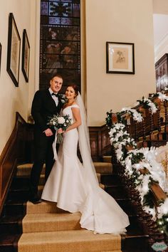 a bride and groom standing on the stairs in front of christmas decorations at their wedding