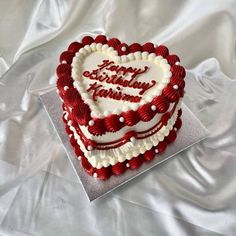 a heart - shaped cake with the words happy birthday written in red and white frosting