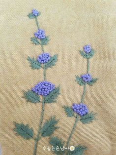 some blue flowers are on a tan cloth