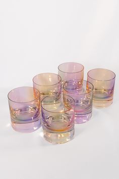 four glasses sitting next to each other on a white surface