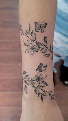 a woman's arm with flowers and butterflies on it