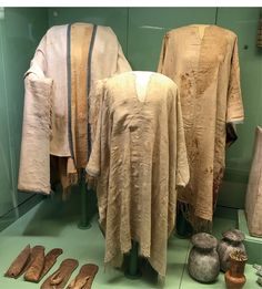 several pieces of clothing are on display in a glass case