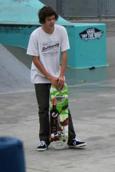 a young man holding a skateboard in his hands