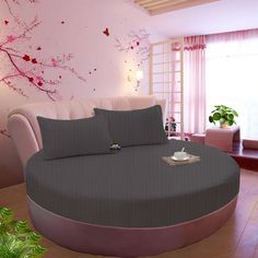 a large round bed in a room with pink walls