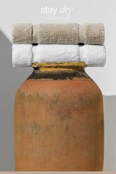 a brown vase with towels on top of it and the words stay dry written in white