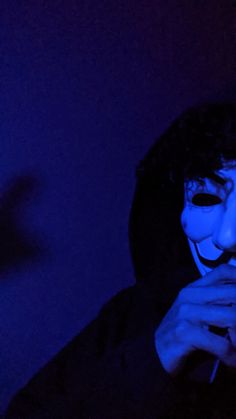 a man with his face painted blue in the dark