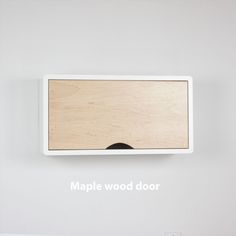 a white wall with a wooden door hanging on it's side and the words maple wood door above it