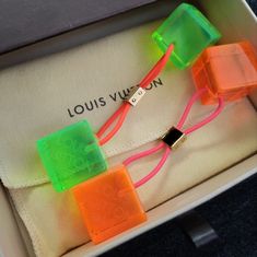 Set Of 2 Beautiful Y2k Authentic Louis Vuitton Hair Cubes. One Neon Orange And One Neon Green With "Louis Vuitton Paris" Inscribed In Both Cubes. Has Stretchy Pink And Orange Elastic Ties And Gold Tone Metal Hardware To Help Secure Your Hair In Place. These Supercute Cubes Have Minimum Scratches From Being Stored. Louis Vuitton Box And Storage Bag Included! Never Been Worn. *Sn The “Spot” You See In The Pic Is Just The Orange Elastic Showing Through The Translucent Cube. It’s Not A Mark In The Cube Whatsoever. Louis Vuitton Box, Louis Vuitton Paris, Neon Hair, Louis Vuitton Accessories, Neon Orange, Metal Hardware, Neon Green, Gold Tone Metal, Authentic Louis Vuitton