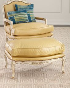 a chair and ottoman with pillows on top of it in front of a white door