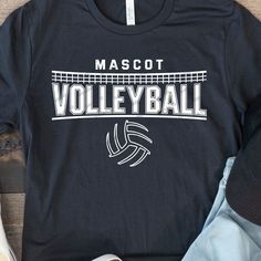 a t - shirt that says mascott volleyball on it next to shoes and sneakers