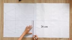 someone is measuring out the length of a piece of paper with a ruler on it