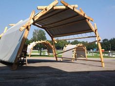 a large wooden structure with two canoes attached to it