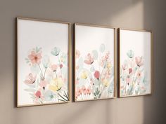 three framed paintings on the wall with flowers in them