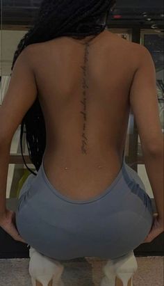 the back of a woman's body with writing on her lower back and foot