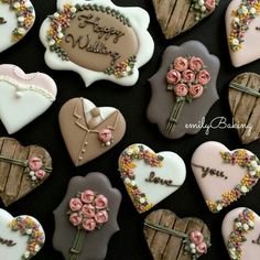 decorated heart shaped cookies with flowers and hearts on them are arranged in the shape of wooden boards