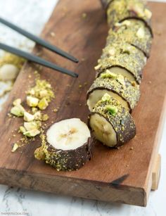 sliced up food sitting on top of a wooden cutting board with chopsticks next to it