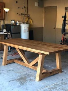 a large wooden table sitting inside of a garage