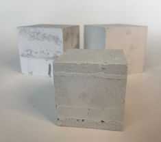 three cement blocks sitting next to each other on a white surface with one block missing